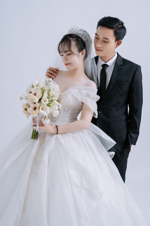 Free A beautiful Asian couple posing together in wedding attire, sharing a special moment. Stock Photo