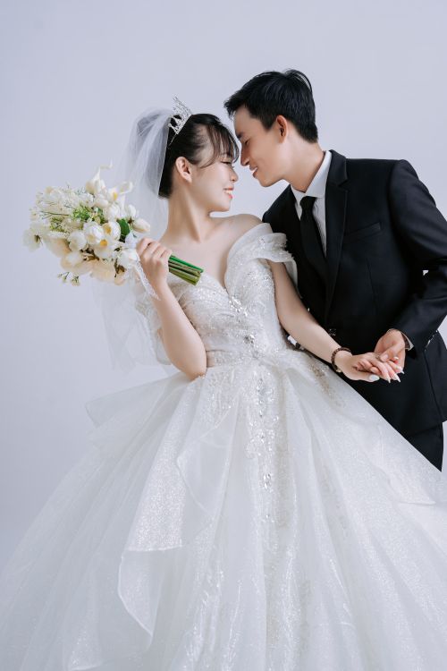 Free Stunning portrait of a newlywed couple in elegant wedding attire sharing a tender moment. Stock Photo