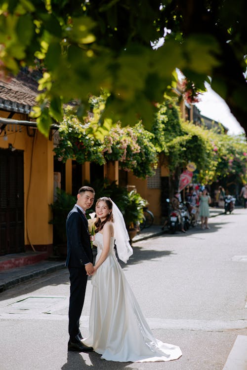 Photo of a Bride and a Groom on the Street