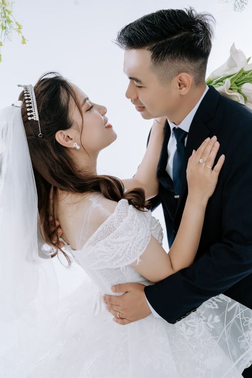 Free A loving couple shares a tender embrace on their wedding day, symbolizing happiness and unity. Stock Photo