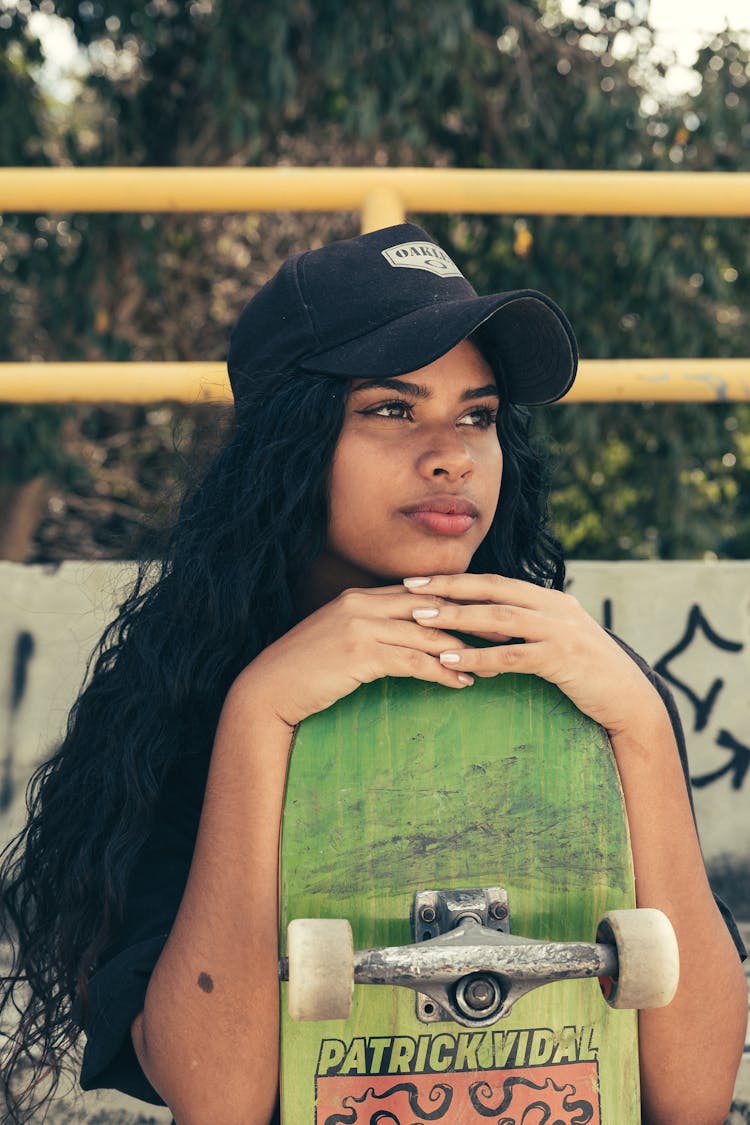 Woman In Cap Holding Skateboard