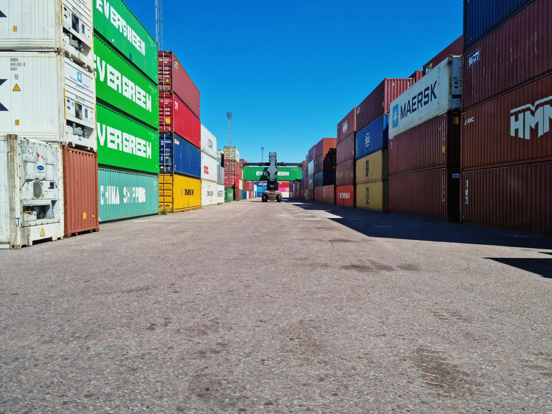 Colorful shipping containers stacked at Muuga Port under a clear blue sky.