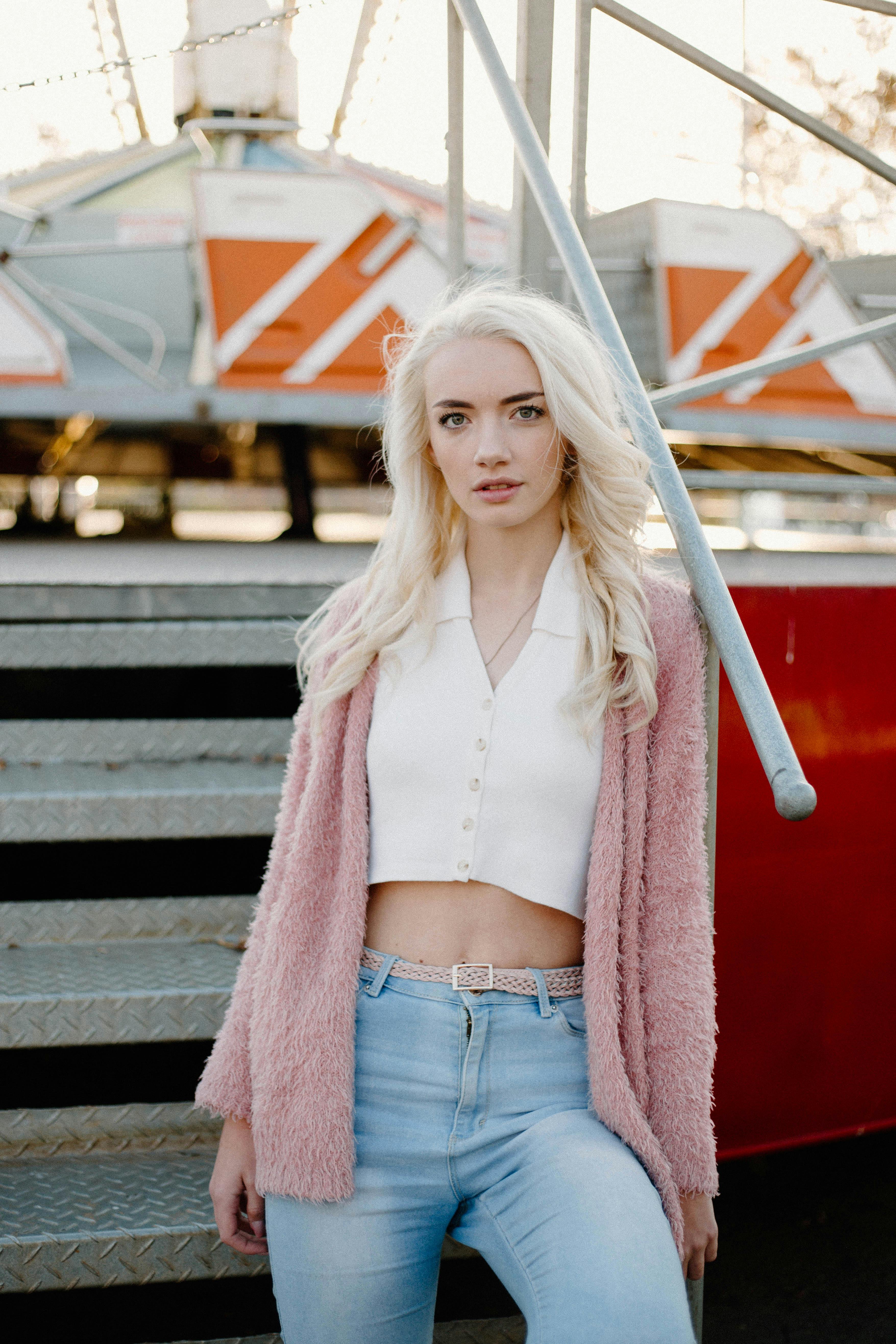 a girl with blond hair leaning on a railing