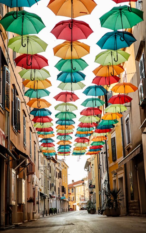 A Hanging Umbrellas on the Street Between Buildings