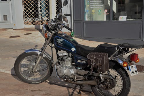 Honda 125 Motorcycle Parked Beside a Shop
