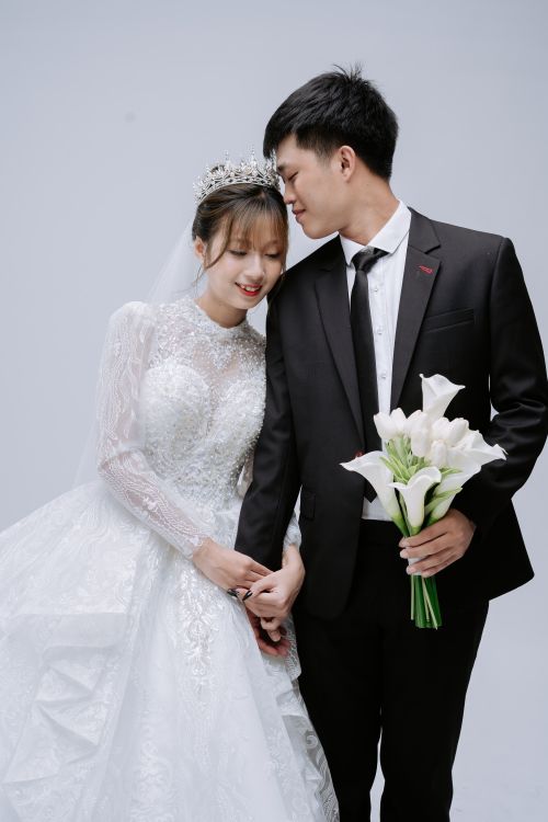 Free An elegant wedding couple in a studio setting, capturing a moment of love and joy. Stock Photo