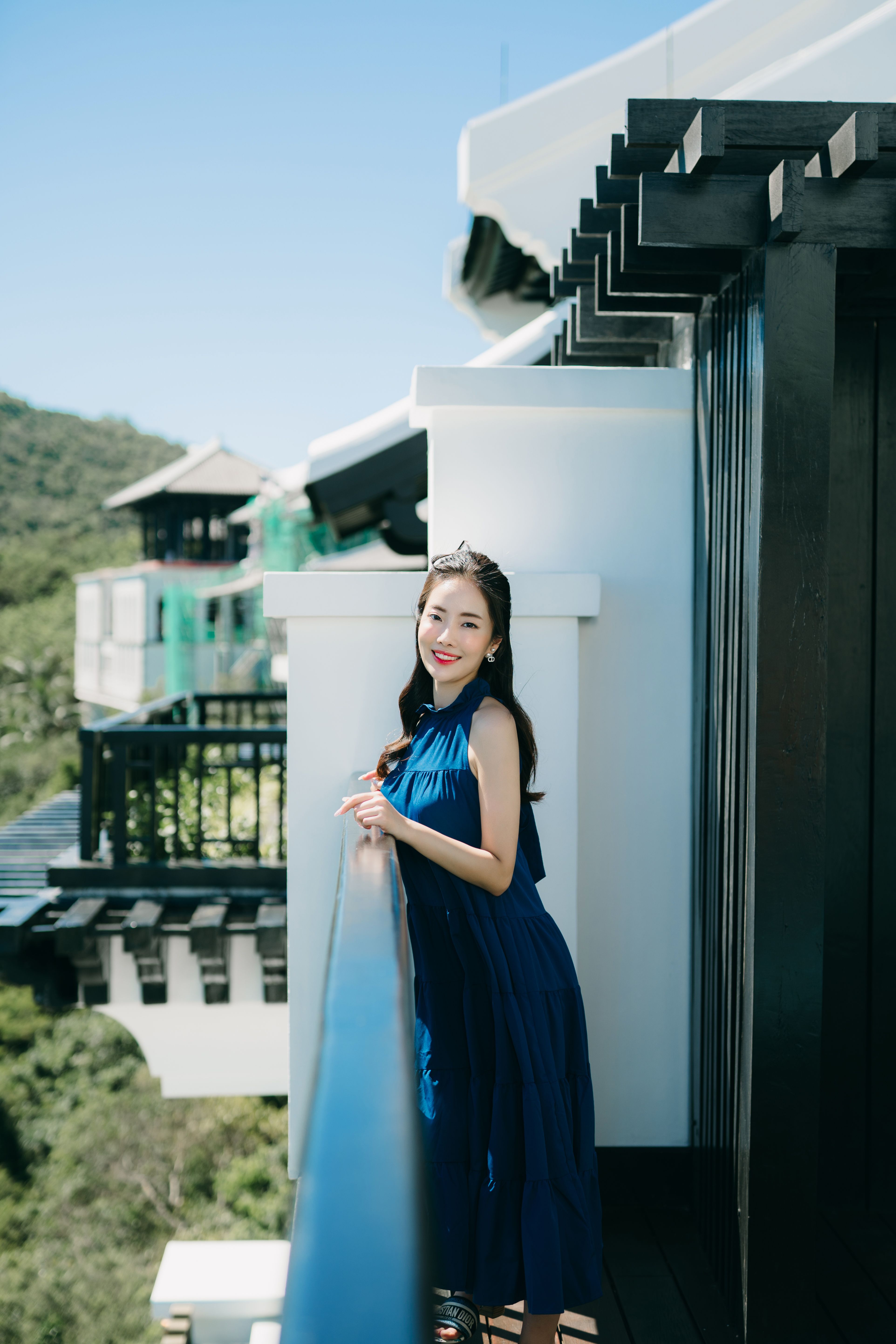 Woman in a Long Blue Dress Standing on a Balcony · Free Stock Photo