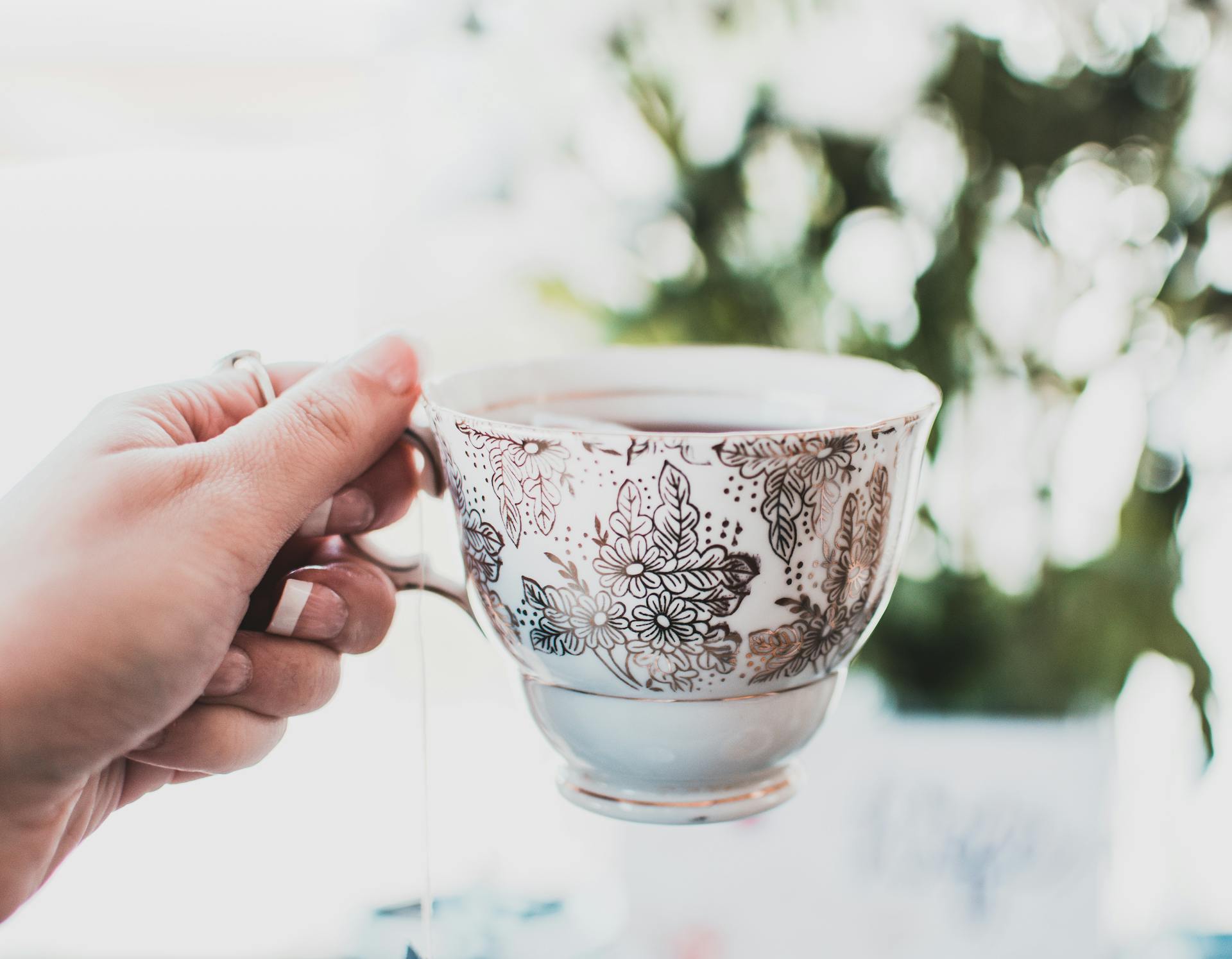 Personne tenant une tasse de thé