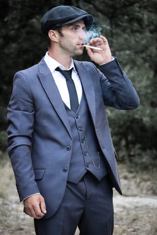 Photograph of a Man with a Flat Cap Smoking a Cigarette