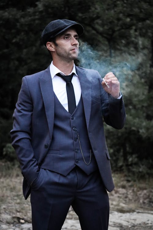 A Man with a Flat Cap Smoking a Cigarette