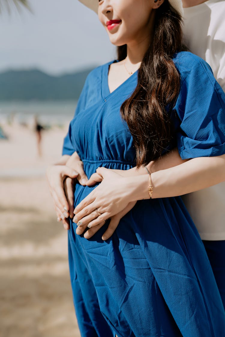 Man And Woman Holding Hands On Womans Pregnant Belly