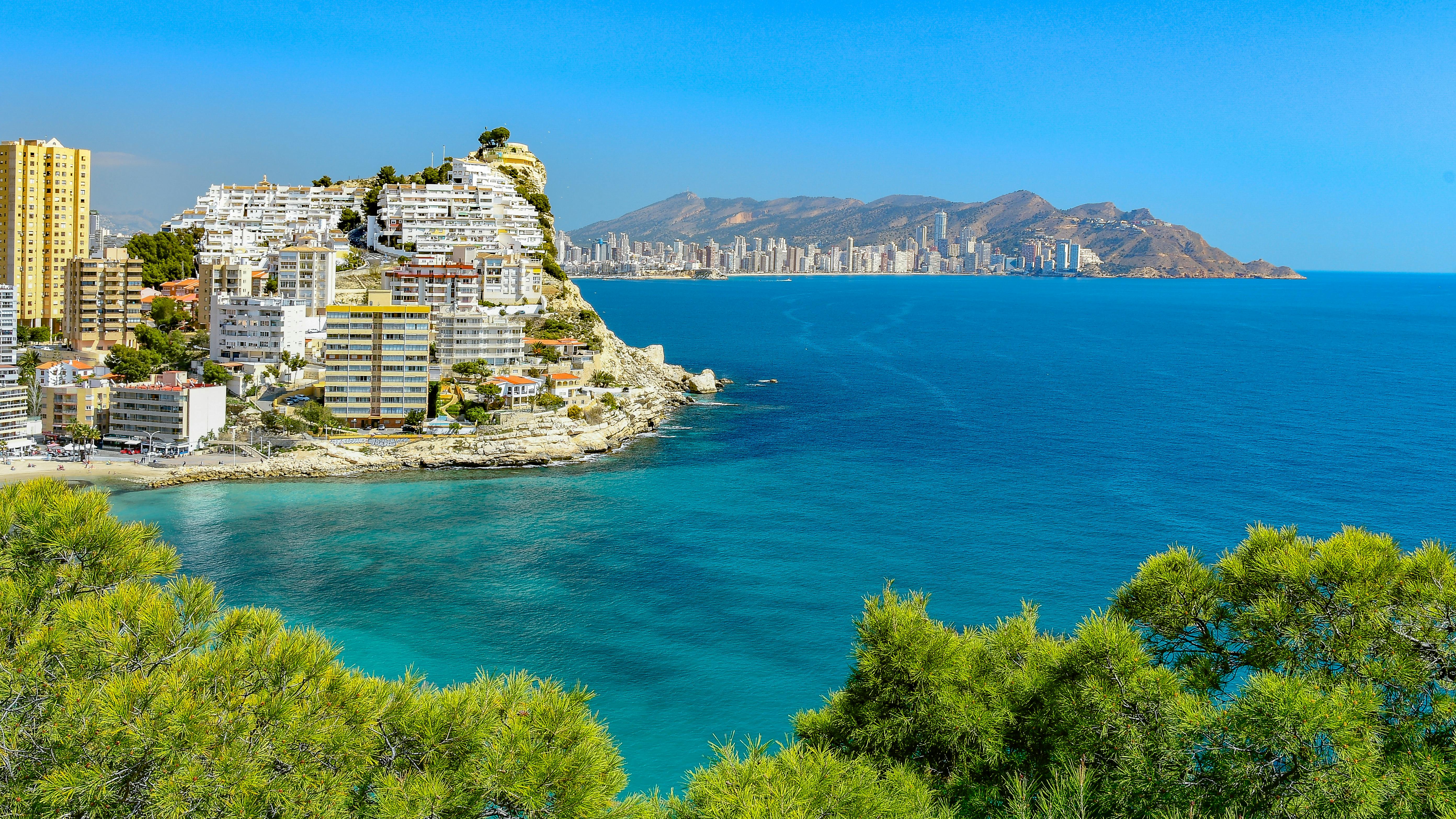 Beautiful summer view of Finestrat coastline and buildings in Spain with clear blue skies.