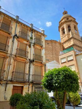 Charming old town buildings with a church tower in Loja, Spain on a sunny day.