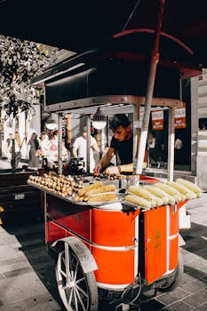 Street vendor selling grilled corn in Istanbul, Türkiye, on a sunny day.