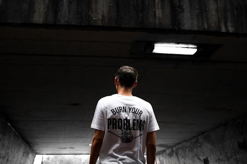 Free Man Wearing White and Black Burn Your Problems Printed T-shirt Stock Photo