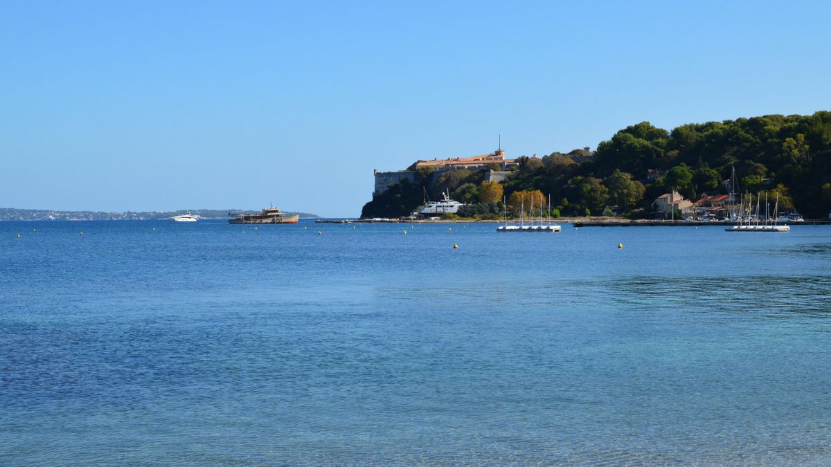 Calm blue water with boats and green shoreline near Sandbanks