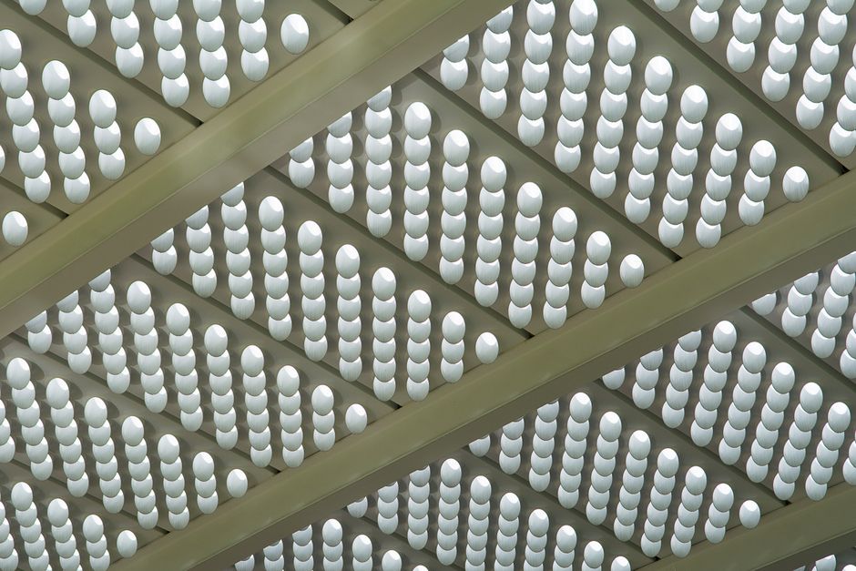 Abstract view of a modern ceiling featuring a futuristic and symmetrical lighting pattern.