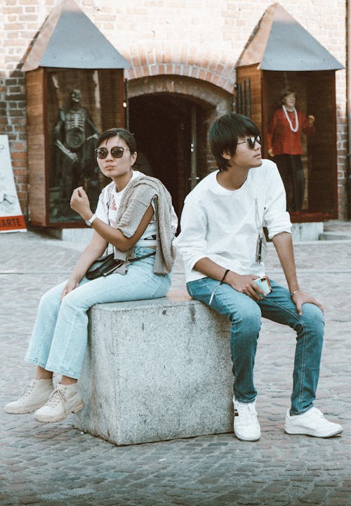Man and Woman Wearing Sunglasses Sitting Beside Each Other 