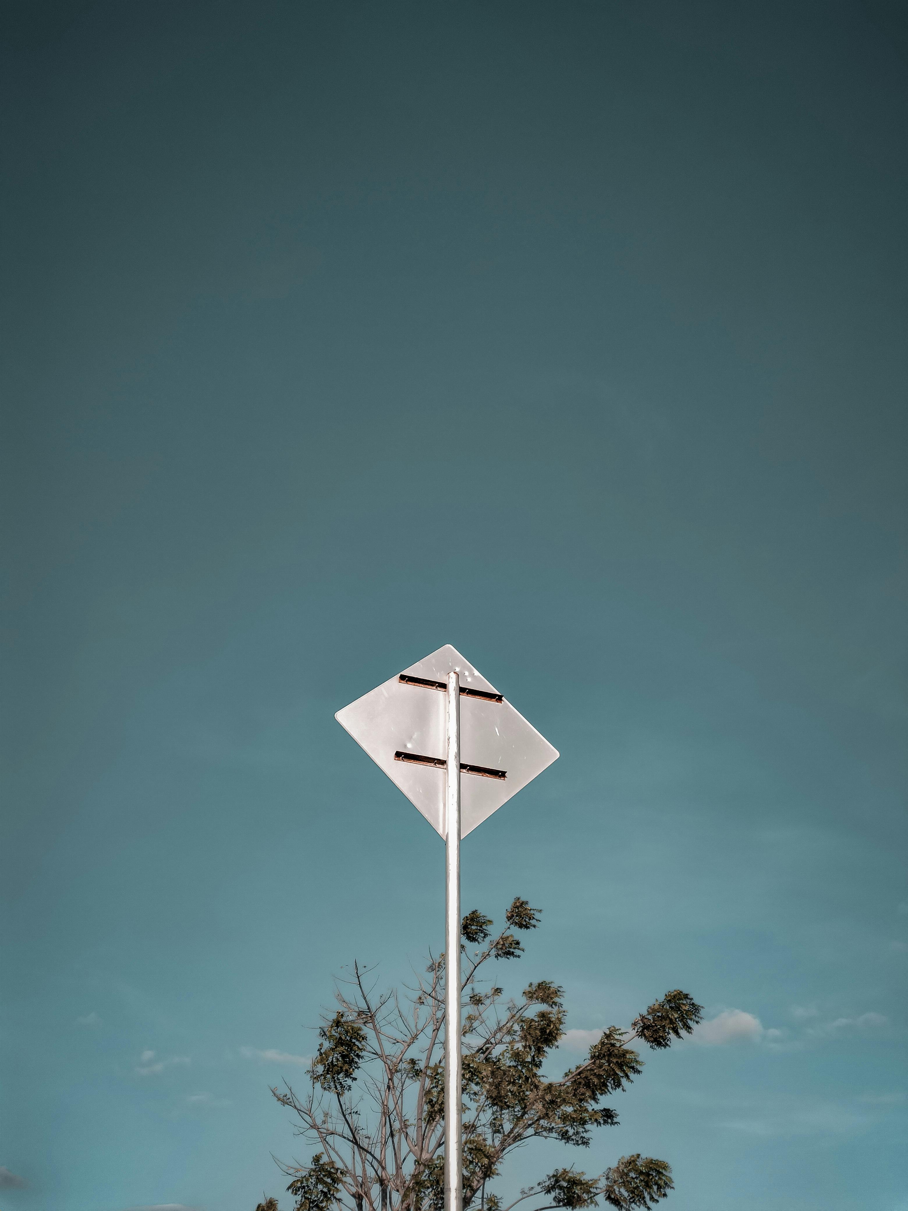 A minimalist photo of a road sign against a clear sky, perfect for design with ample copy space.