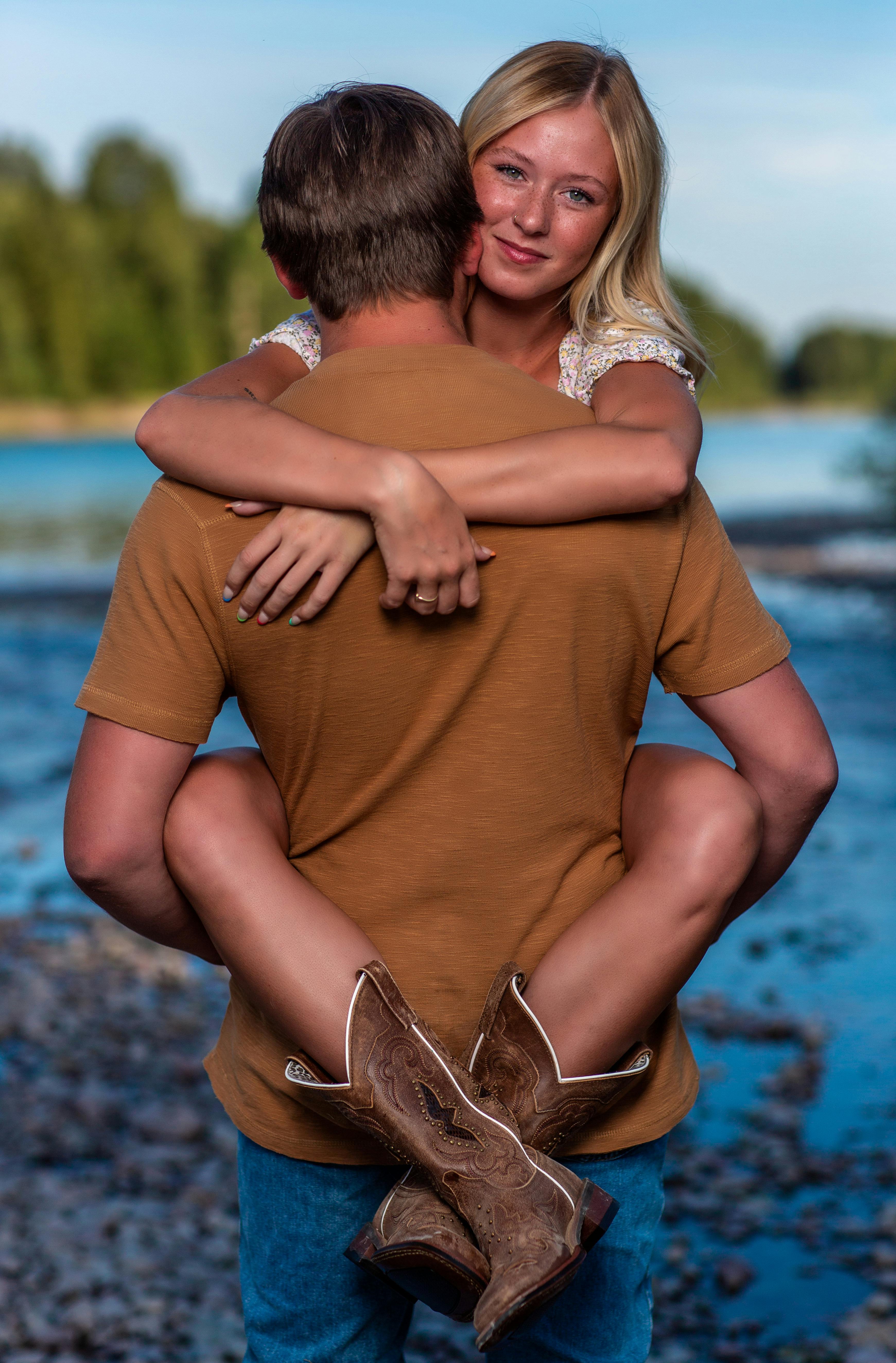 photo of a man in a brown shirt carrying a woman