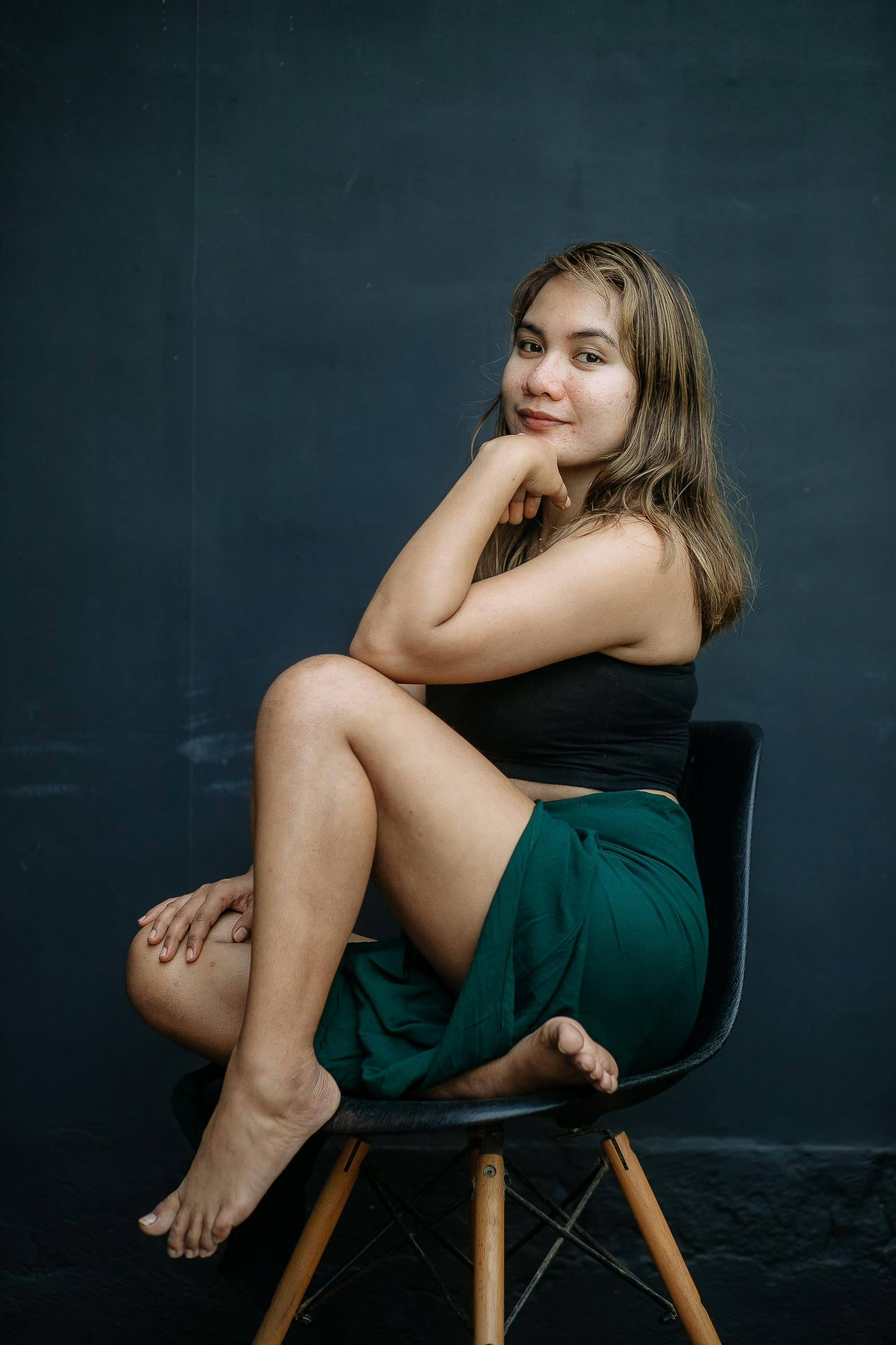 woman in black tube and blue skirt sitting on chair