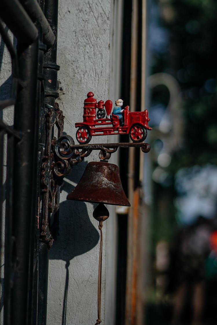 Close-up Of A Vintage Bell With A Fire Truck Decoration 