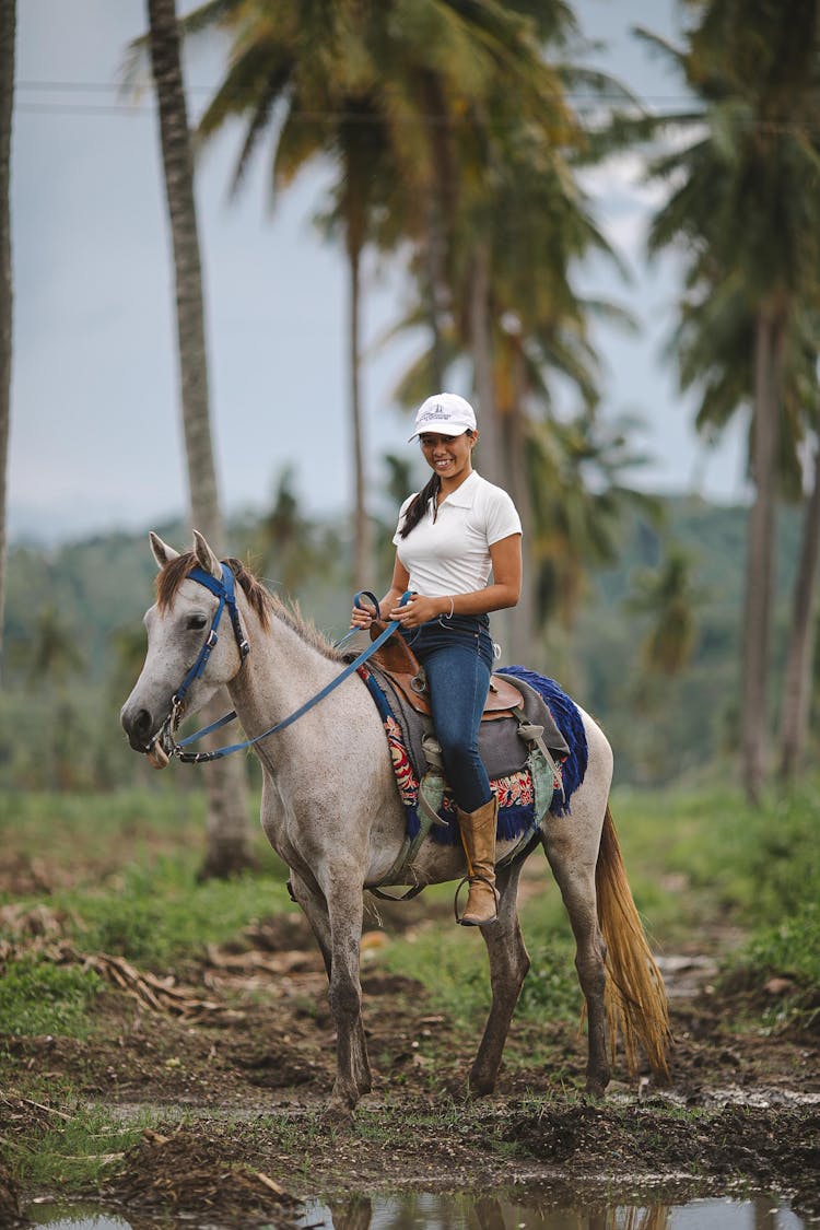 Woman Riding Horse Among Palm Trees