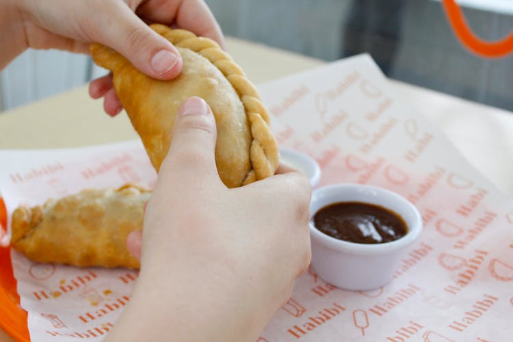 Person Holding An Empanada 