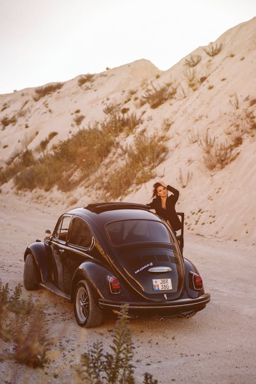 A Woman Standing by a Vintage Car