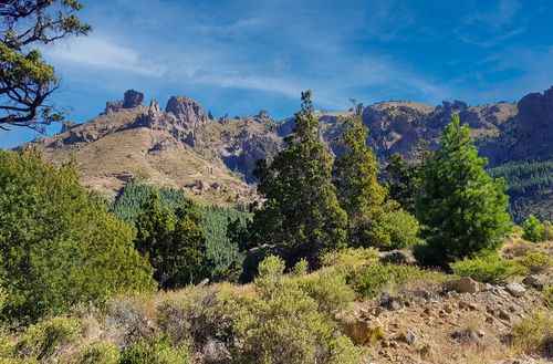 Free Explore the stunning mountain landscape with lush green foliage under a clear blue sky. Stock Photo