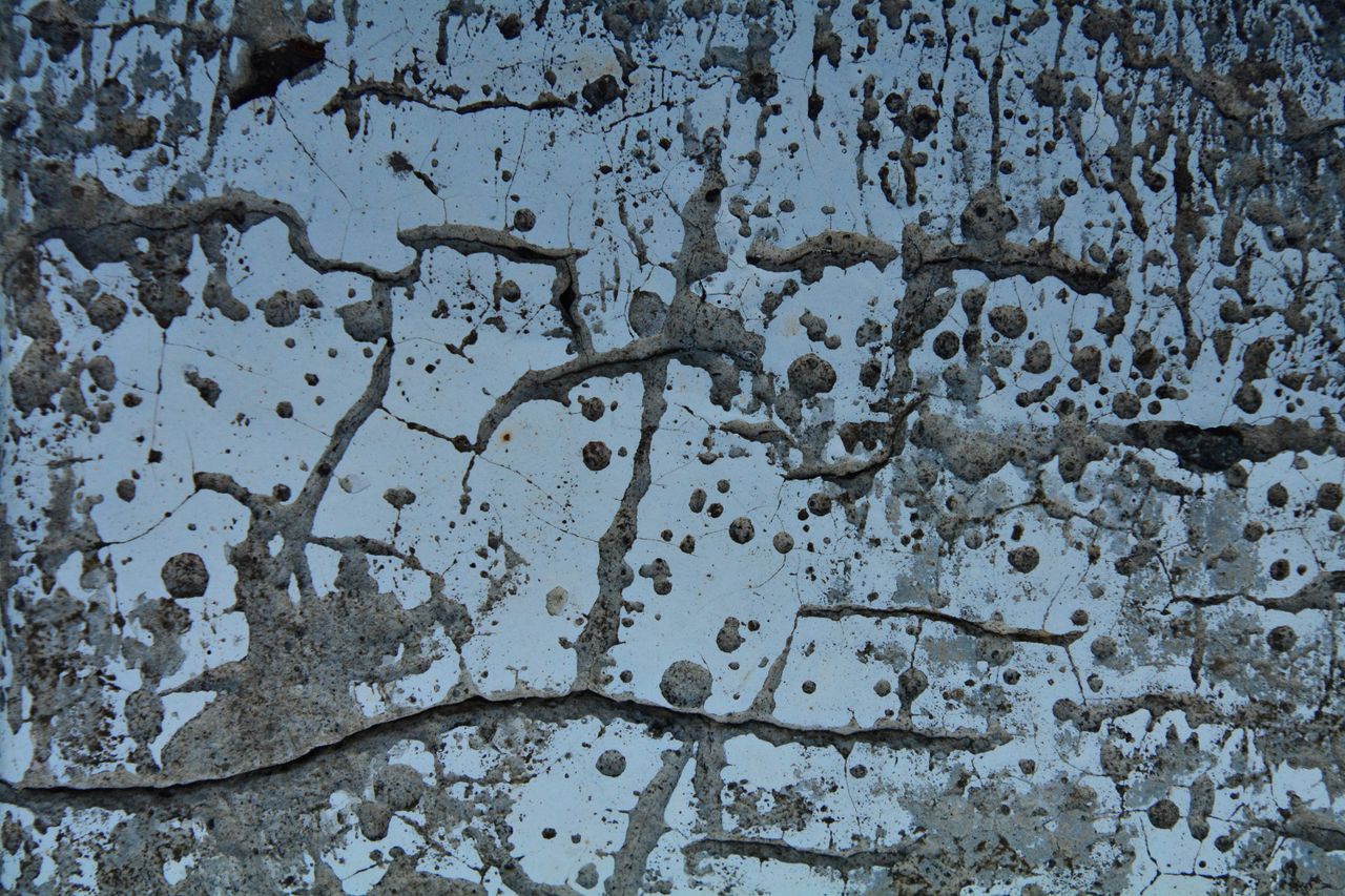 abstract capture of a textured concrete surface with cracks and stains