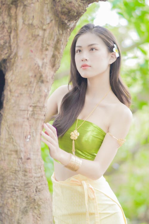 A Woman in Green Tube Top Behind a Tree