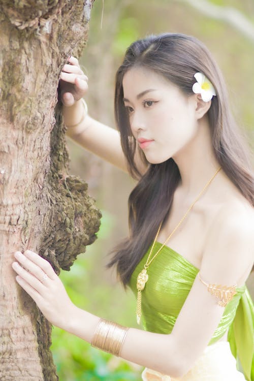 Woman in a Green Top Posing on a Tree
