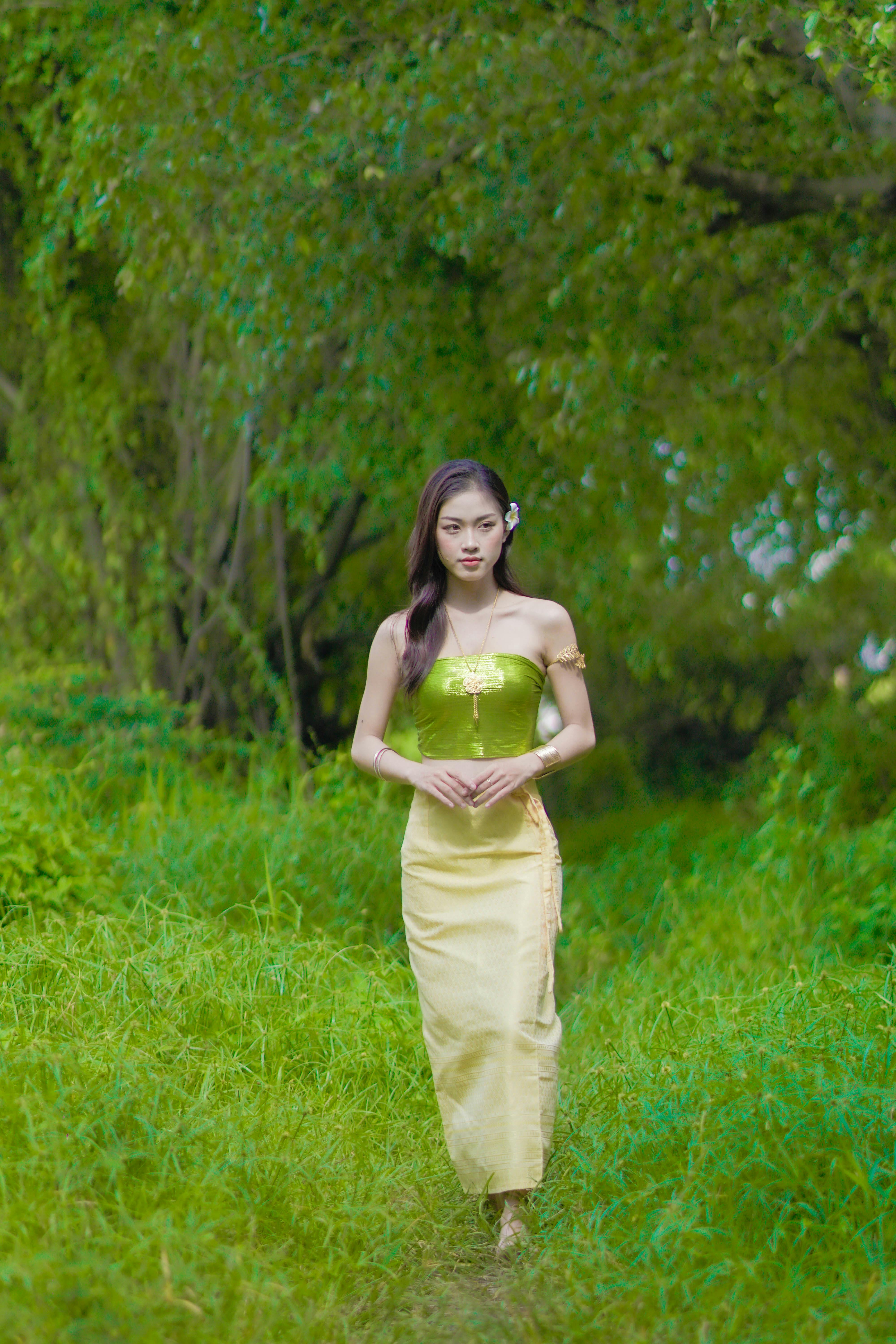 Woman in Yellow Green Tube Top and Yellow Skirt Walking on Green Grass