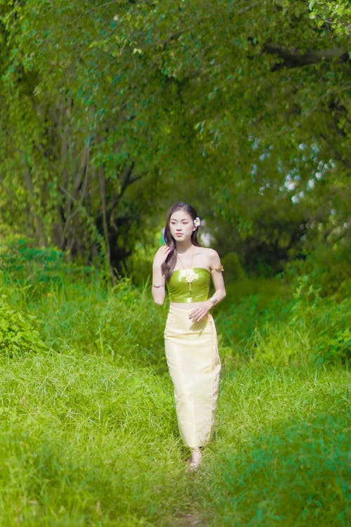Woman in a Skirt Walking on Green Grass