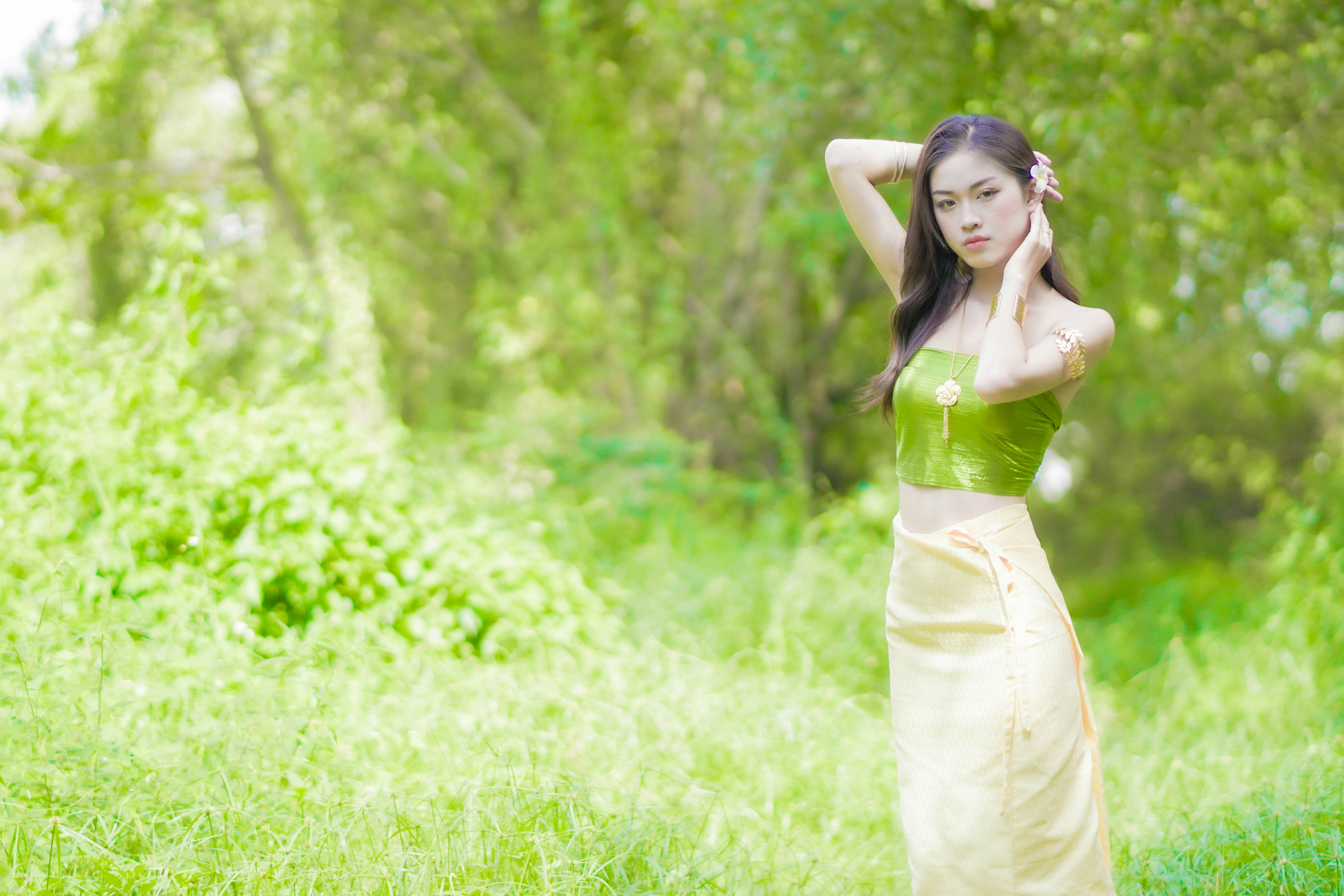 A Woman in Green Tube Top and Yellow Skirt Standing on Grass · Free