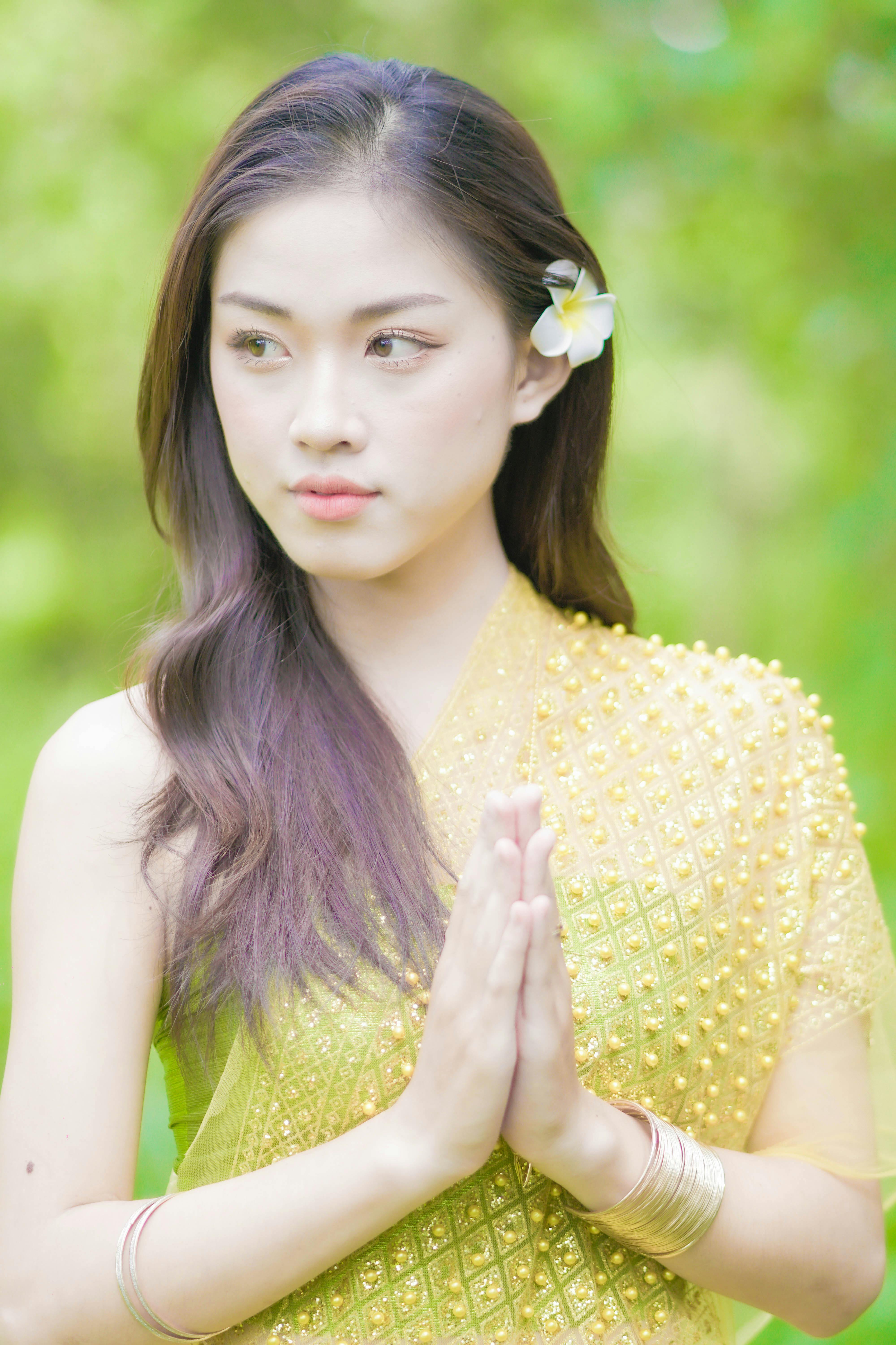 a woman with yellow scarf holding her hands together