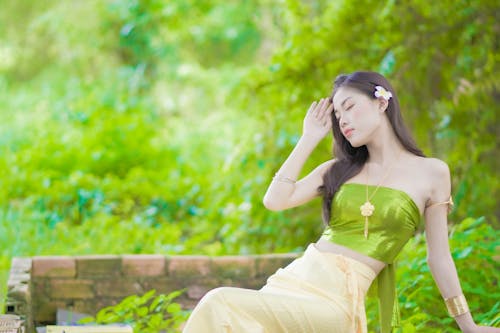 Woman in Tube Top Sitting on Brick Bench