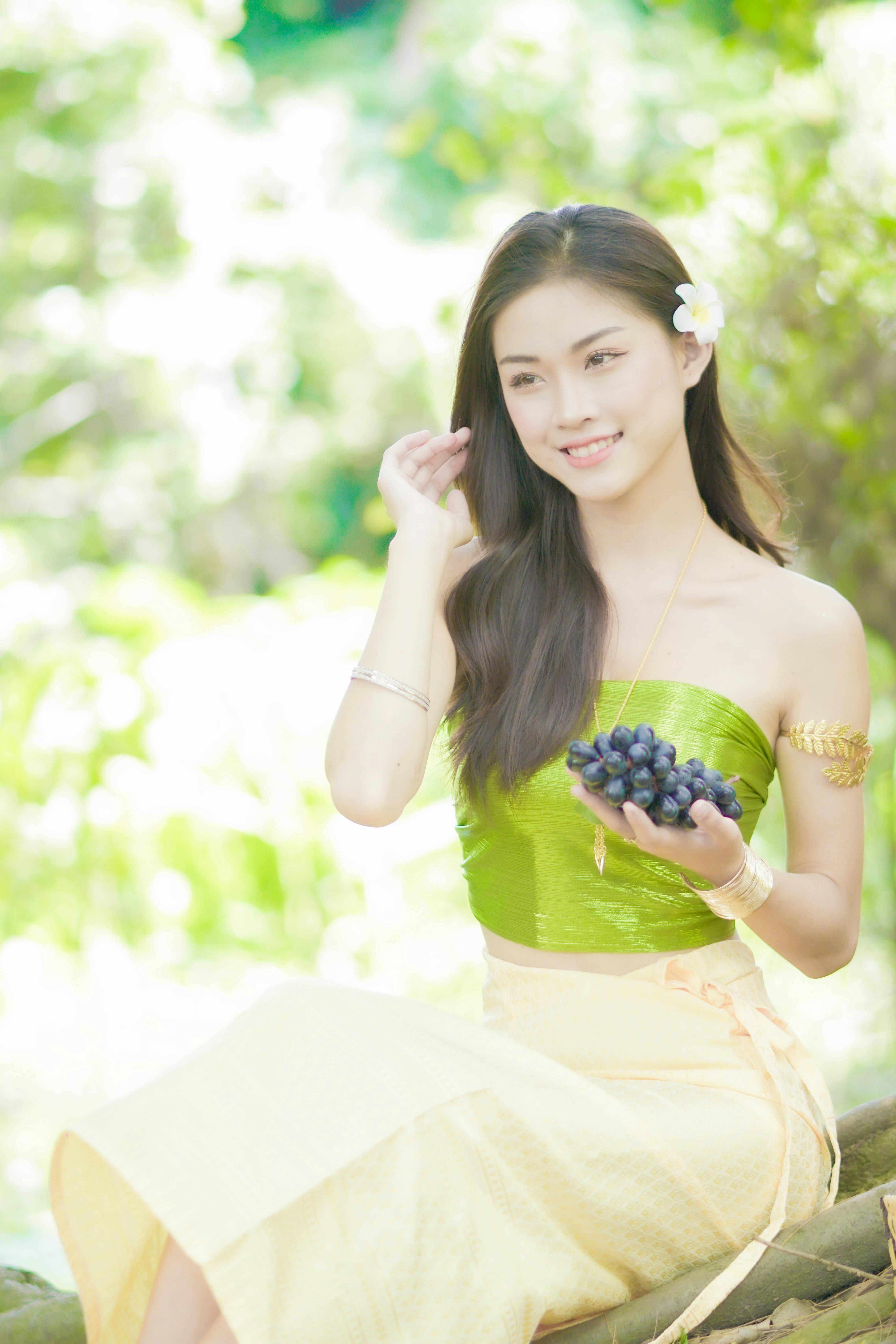 a woman holding a bunch of grapes