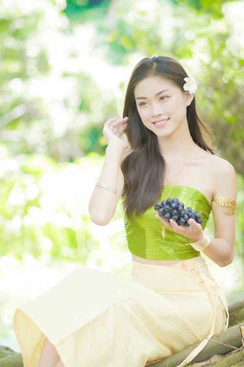 A Woman Holding a Bunch of Grapes