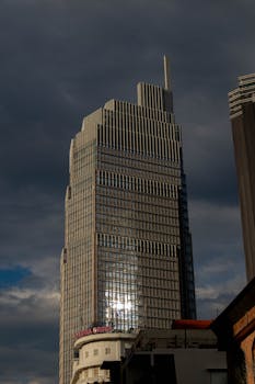 A striking modern skyscraper in Ho Chi Minh City with a dramatic moody sky.