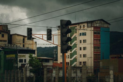 Street view of Mérida with buildings, traffic light, and overcast sky.