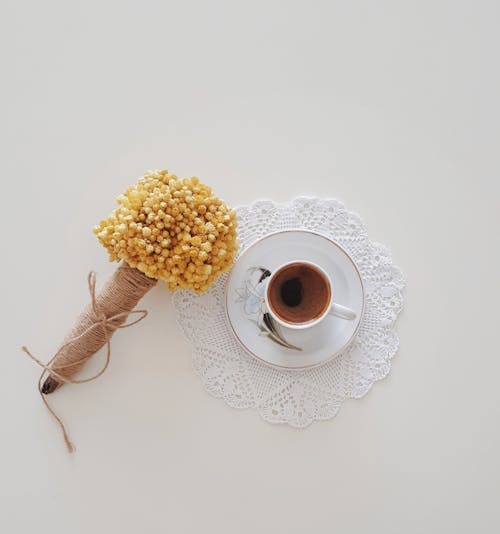 A Cup of Coffee and Flowers on a Table