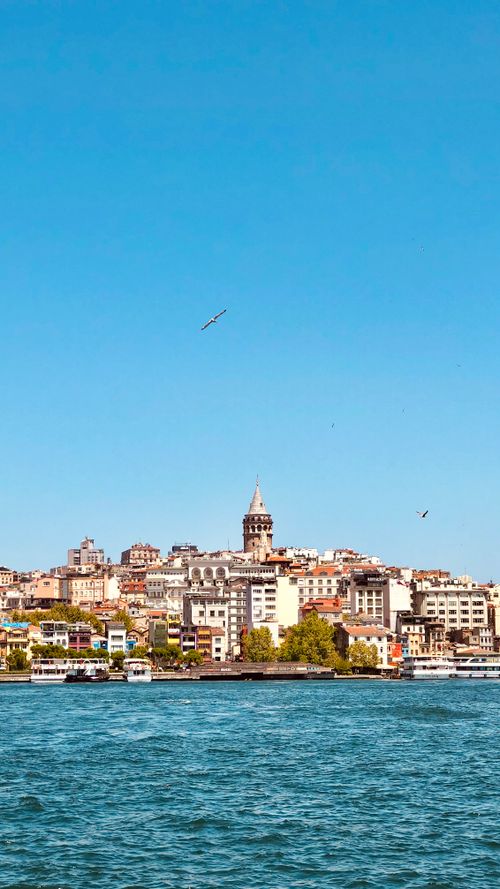 Free Beautiful view of the Galata Tower and Istanbul skyline with the Bosphorus in the foreground under a clear blue sky. Stock Photo