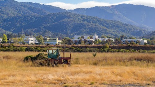 Tractor on a Field in a Mountain Valley 