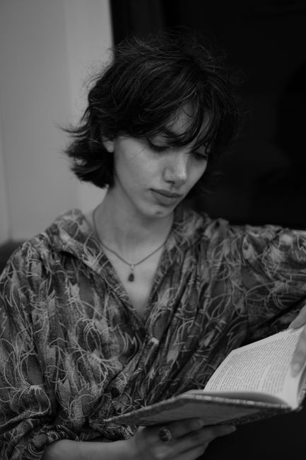 Black and white image of a woman absorbed in reading, creating a thoughtful atmosphere.
