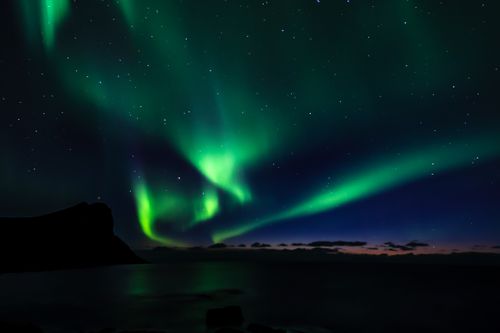 Free Capture of vibrant Northern Lights over a serene Myrland landscape in Norway with starry sky. Stock Photo