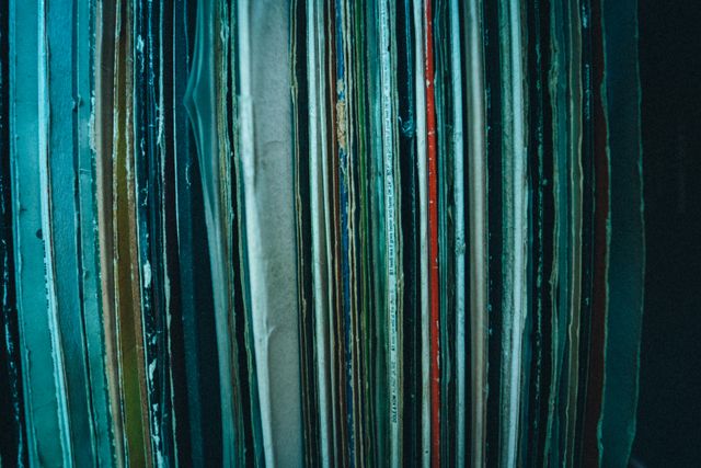 Spines of a stacked record collection — photo by Volker Thimm on Pexels