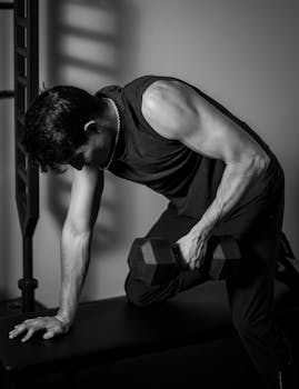 A man working out with a dumbbell indoors, showcasing strength and fitness.