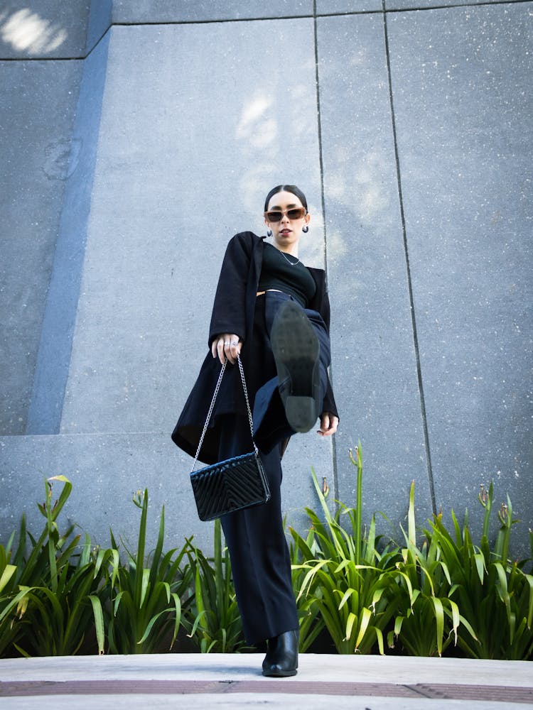 A Woman Wearing Black Showing Her Shoe Sole